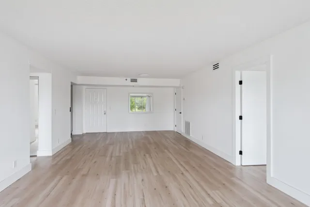 a view of an empty room with wooden floor