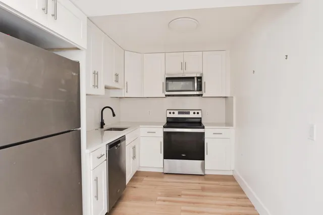 a kitchen with stainless steel appliances a sink a stove a microwave and cabinetry