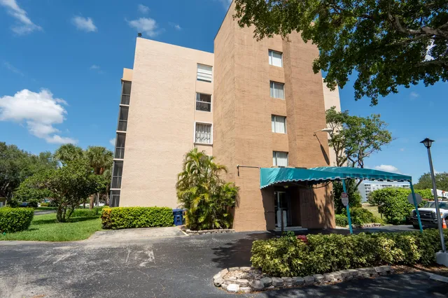 front view of a house with a yard and potted plants