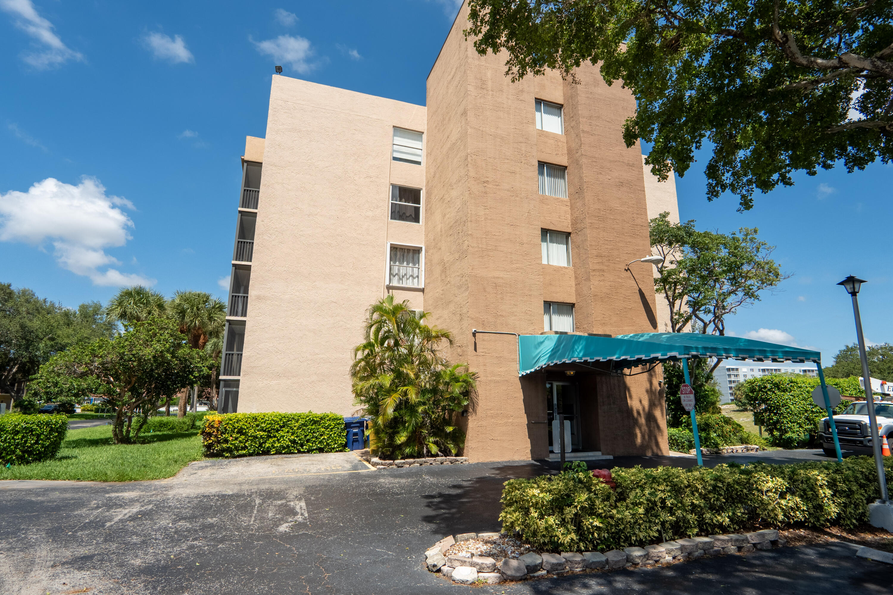 5260 Northwest 2nd Avenue, Unit 105 Boca Raton, FL 33487 - Photo 21 of 24 front view of a house with a yard and potted plants