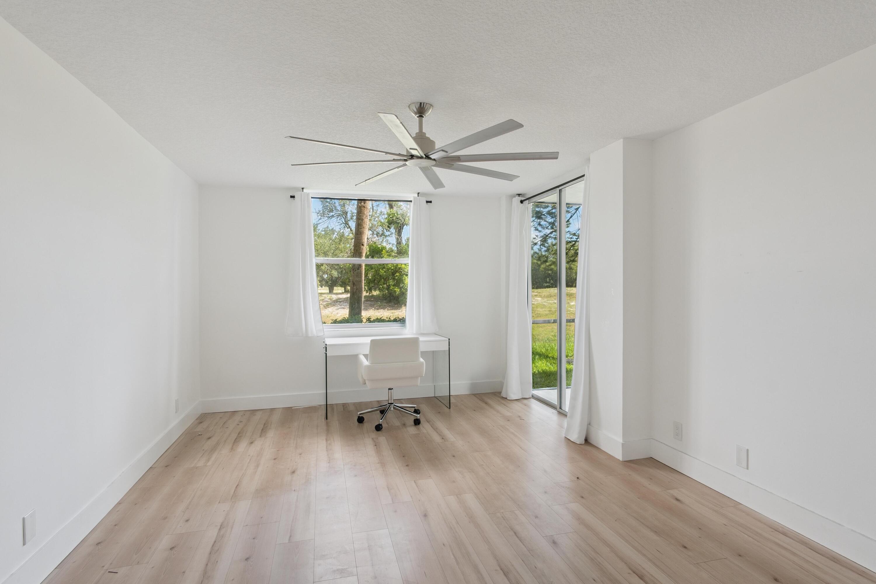 5260 Northwest 2nd Avenue, Unit 105 Boca Raton, FL 33487 - Photo 4 of 24 an empty room with windows and a ceiling fan