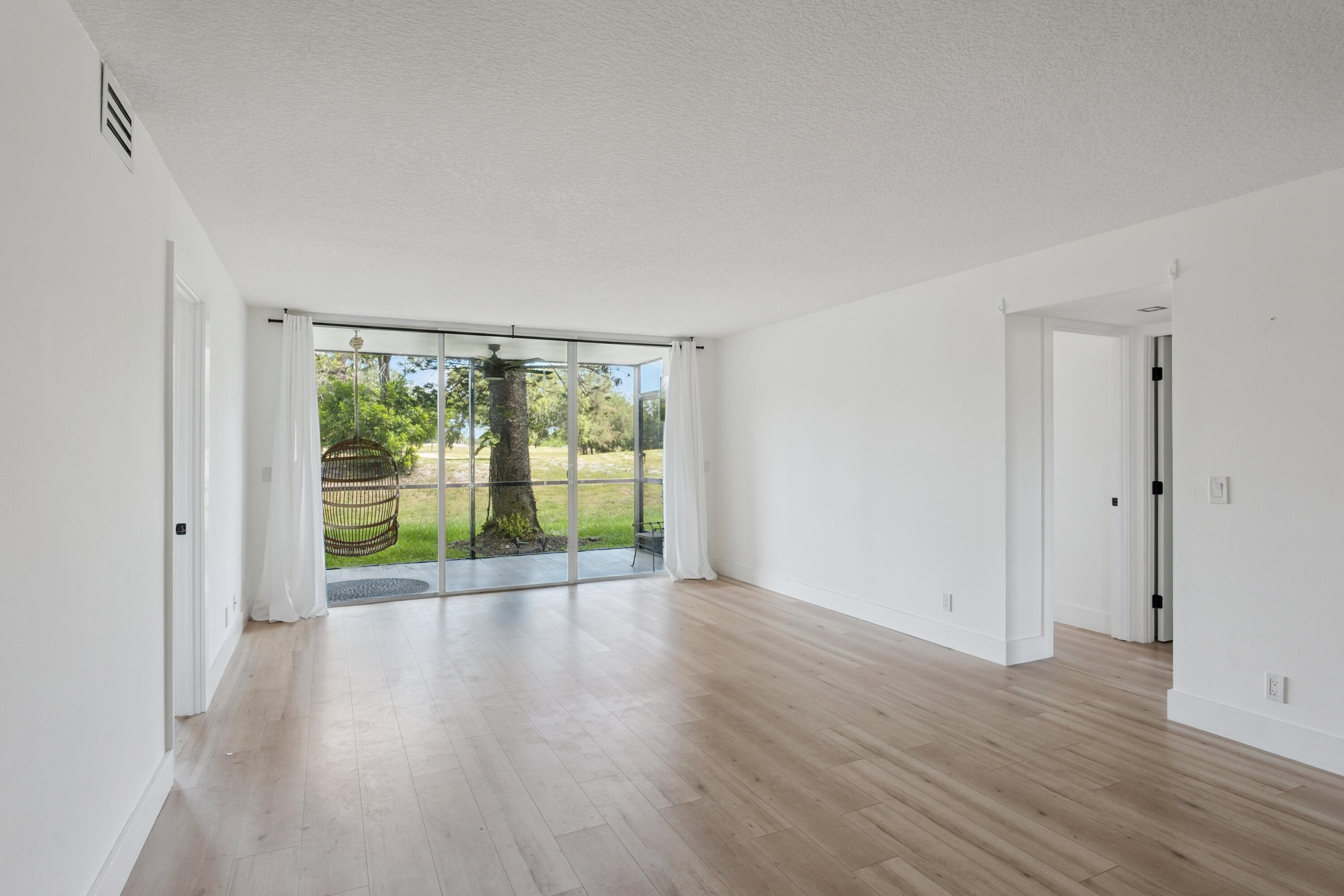 5260 Northwest 2nd Avenue, Unit 105 Boca Raton, FL 33487 - Photo 8 of 24 a view of an empty room with wooden floor and a window
