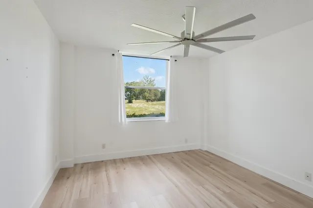 an empty room with a window and wooden floor