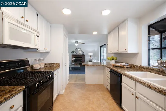 a kitchen with granite countertop a stove sink and cabinets