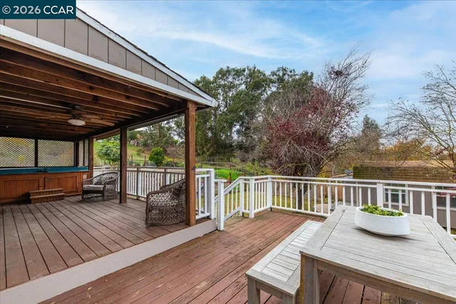a view of a deck with wooden floor barbeque oven and furniture