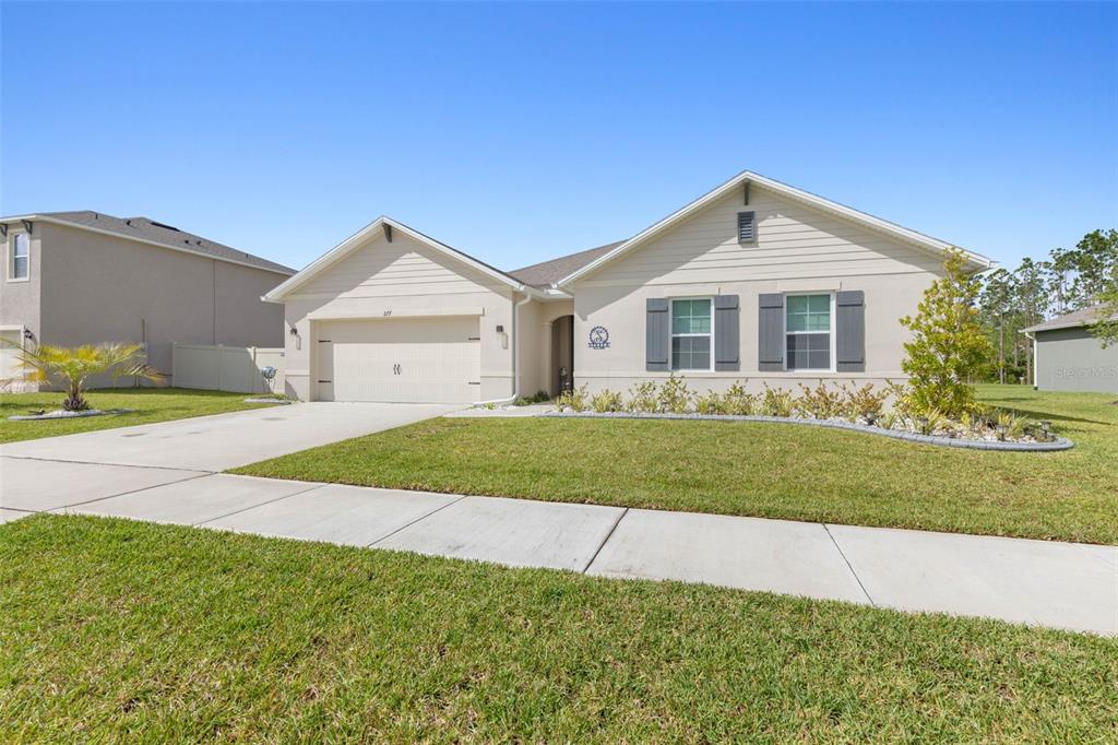277 Sunset Point Drive Ormond Beach, FL 32174 - Photo 4 of 52 a front view of a house with a yard and garage