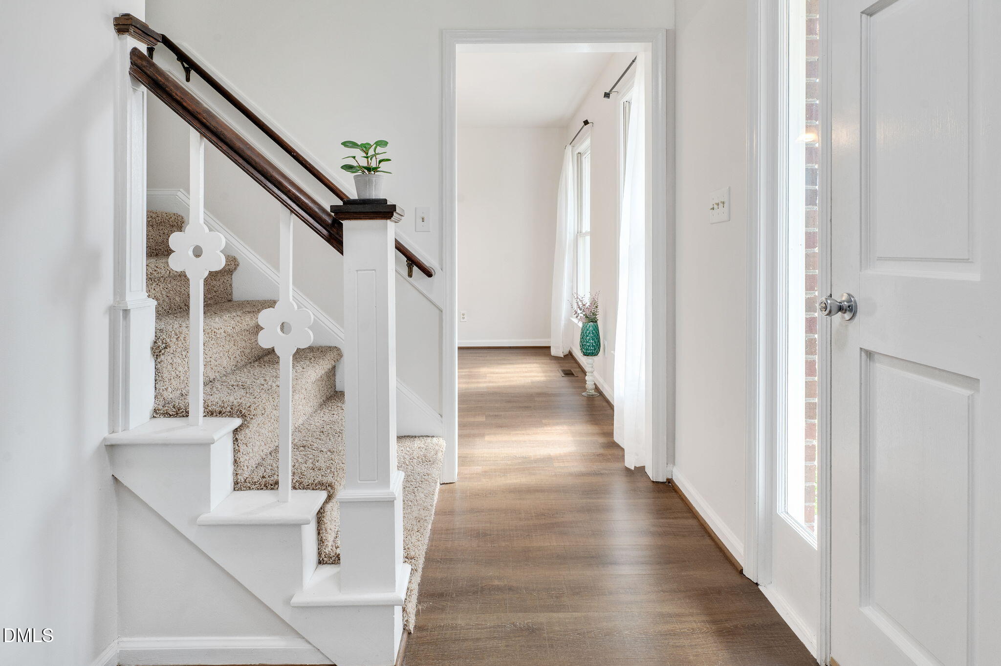 9205 Tree Meadow Lane Raleigh, NC 27603 - Photo 5 of 44 a view of a hallway with wooden floor and staircase