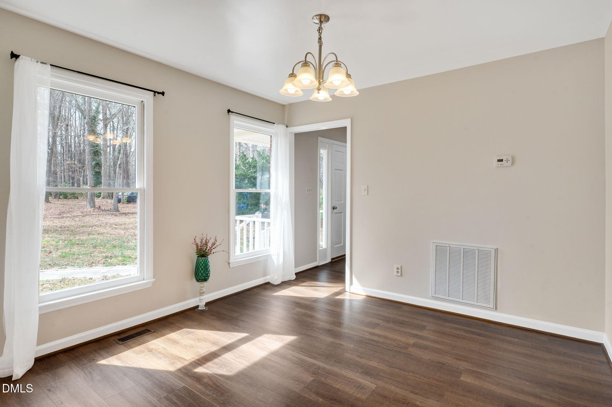 9205 Tree Meadow Lane Raleigh, NC 27603 - Photo 6 of 44 a view of an empty room with wooden floor and a window