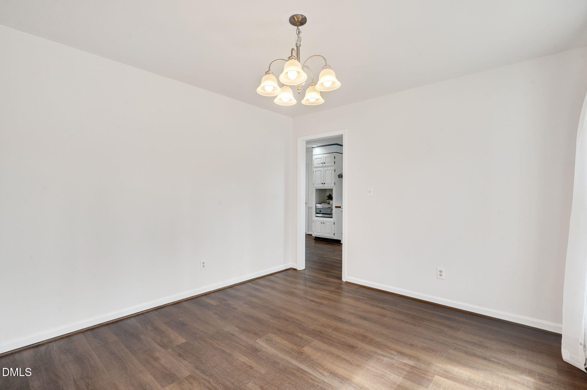 9205 Tree Meadow Lane Raleigh, NC 27603 - Photo 7 of 44 a view of an empty room with wooden floor and a window