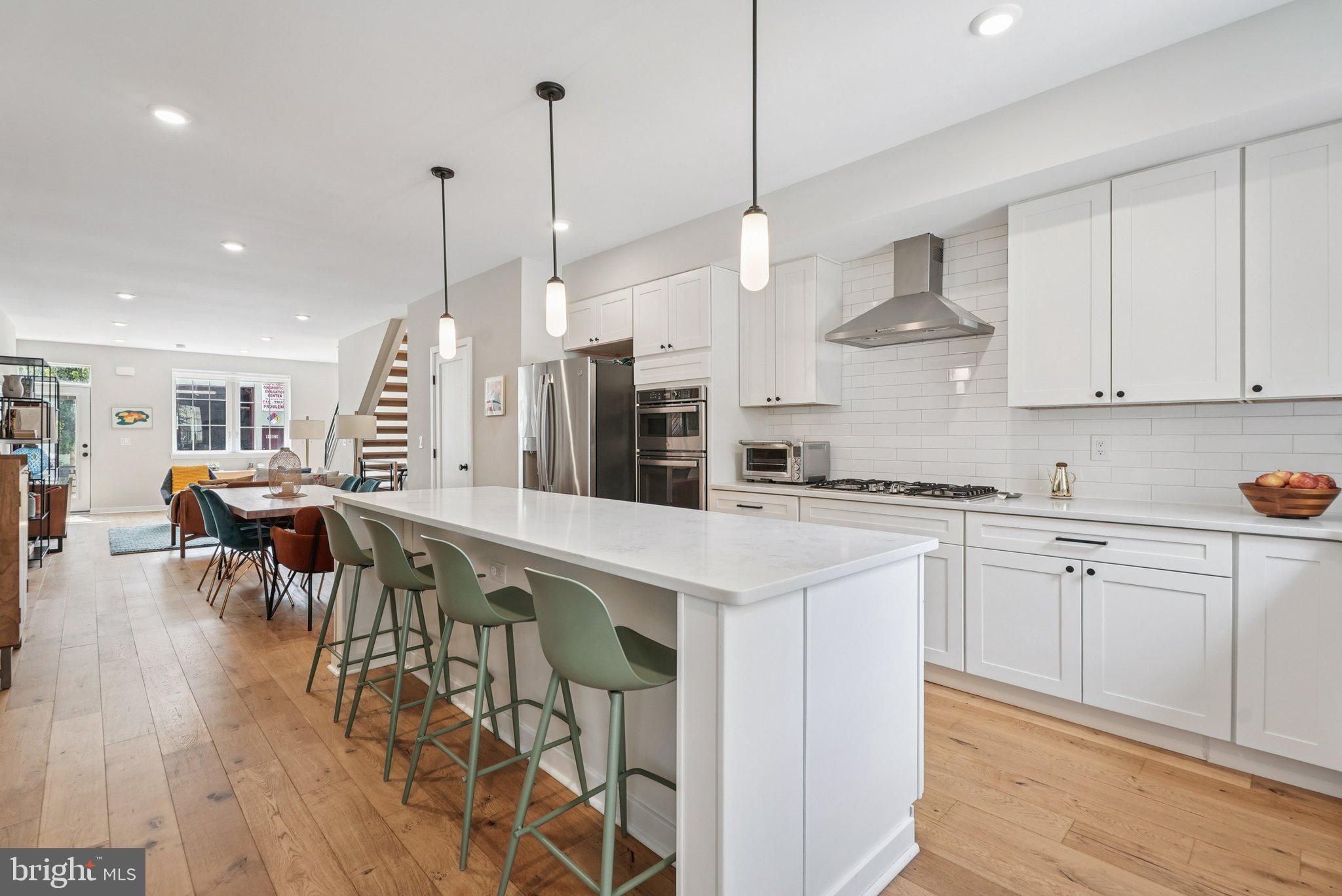 919 Reed Street Philadelphia, PA 19147 - Photo 11 of 28 a kitchen with stainless steel appliances kitchen island granite countertop a table chairs sink and cabinets