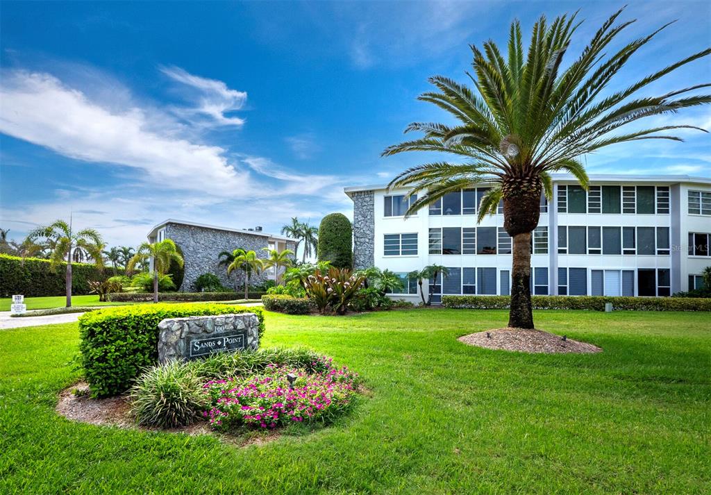 100 Sands Point Road, Unit 211 Longboat Key, FL 34228 - Photo 1 of 1 a front view of a house with garden and trees
