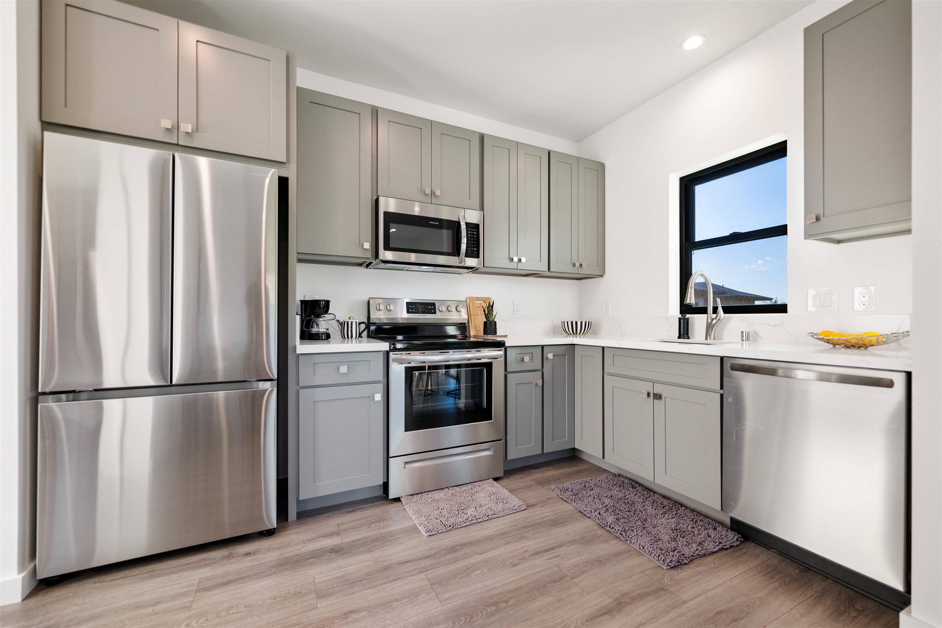 804 Anapuni Loop Lahaina, HI 96761 - Photo 47 of 49 a kitchen with white cabinets white stainless steel appliances and wooden floors