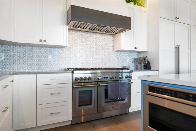 a kitchen with stainless steel appliances white cabinets and a stove