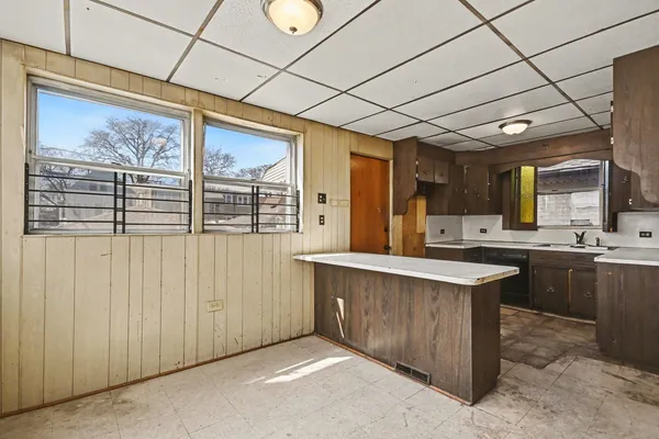 a kitchen with stainless steel appliances granite countertop a sink window and cabinets