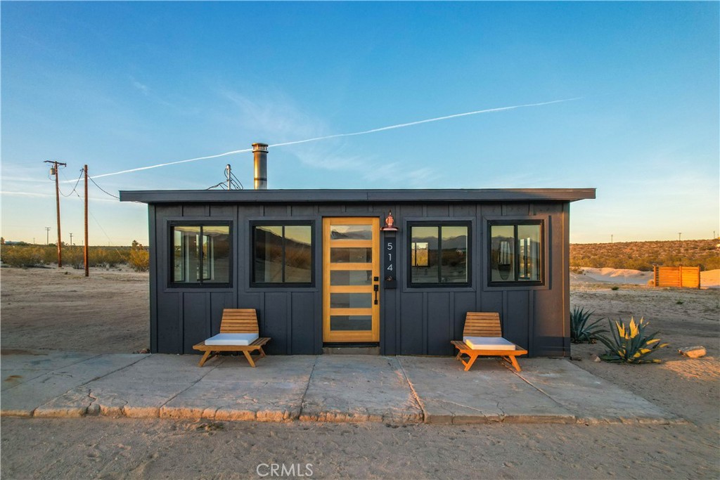a backyard of a house with barbeque oven table and chairs
