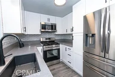 a kitchen with stainless steel appliances granite countertop a refrigerator sink and stove