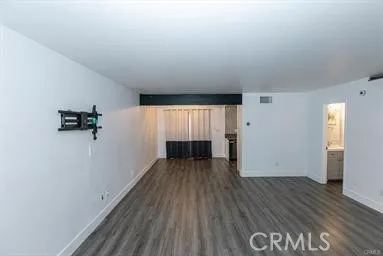 an empty room with wooden floor and window