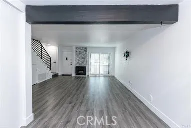 a view of empty room with wooden floor and fireplace