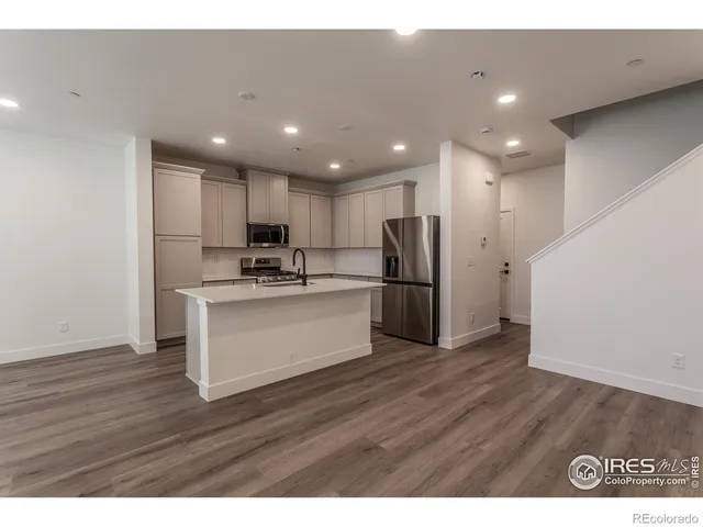 a view of kitchen with granite countertop stainless steel appliances refrigerator and microwave