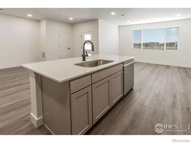 a kitchen with a sink and wooden floor