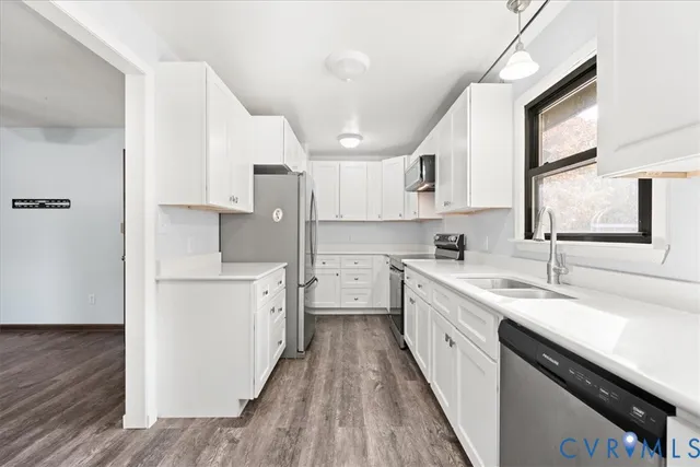 a kitchen with white cabinets and black appliances
