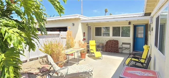 a view of a patio with table and chairs and potted plants