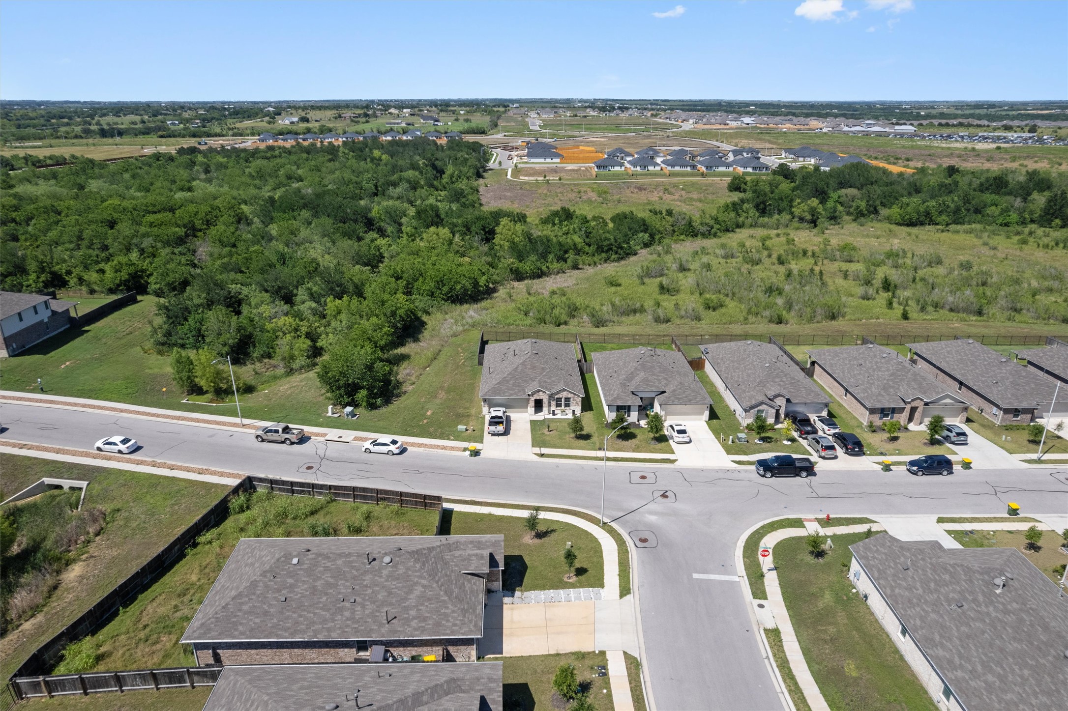 19912 Abigail Fillmore Road Manor, TX 78653 - Photo 2 of 31 An aerial perspective reveals a neighborhood with surrounding natural landscapes and undeveloped plots.