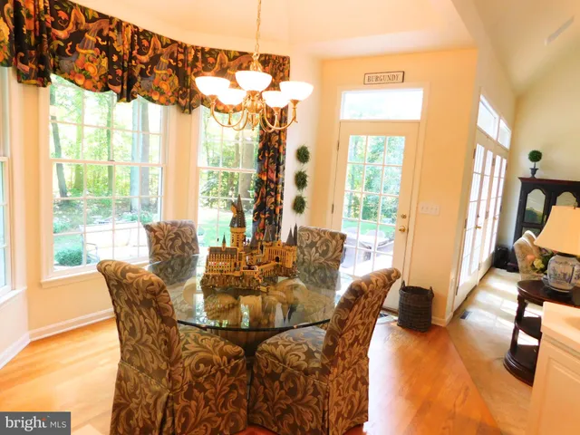 a living room with furniture floor to ceiling window and wooden floor