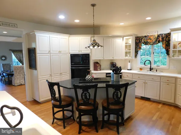 a kitchen with kitchen island a sink stainless steel appliances and cabinets