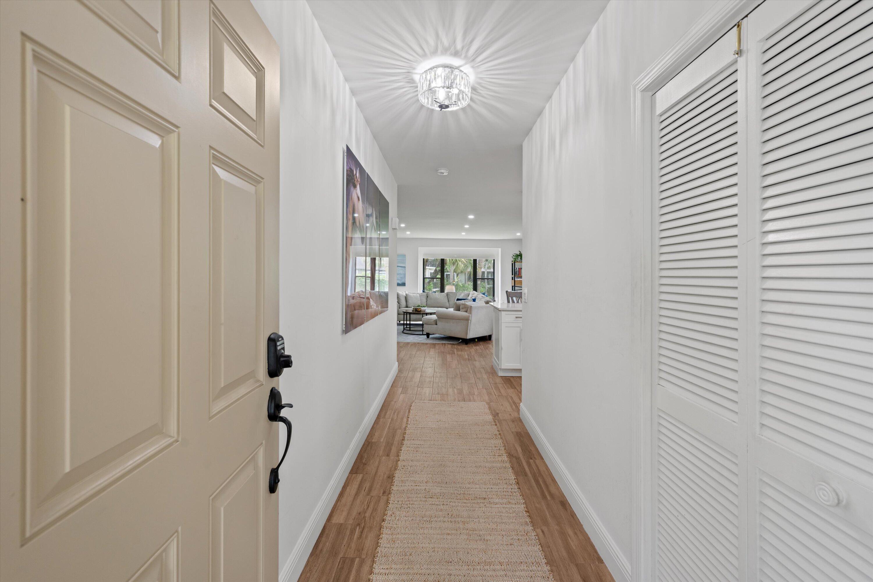 13400 Polo Road West, Unit 203 Wellington, FL 33414 - Photo 2 of 26 a view of a hallway with workspace and wooden floor
