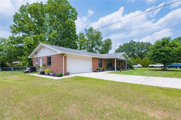 a front view of a house with a yard and trees