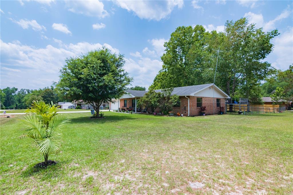 126 Southwest Mockingbird Way Lake City, FL 32024 - Photo 12 of 37 a yellow house in middle of the green field