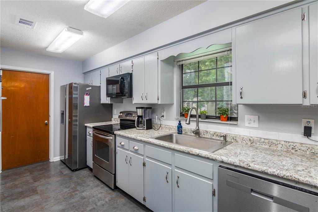 126 Southwest Mockingbird Way Lake City, FL 32024 - Photo 22 of 37 a kitchen with a sink stove and microwave