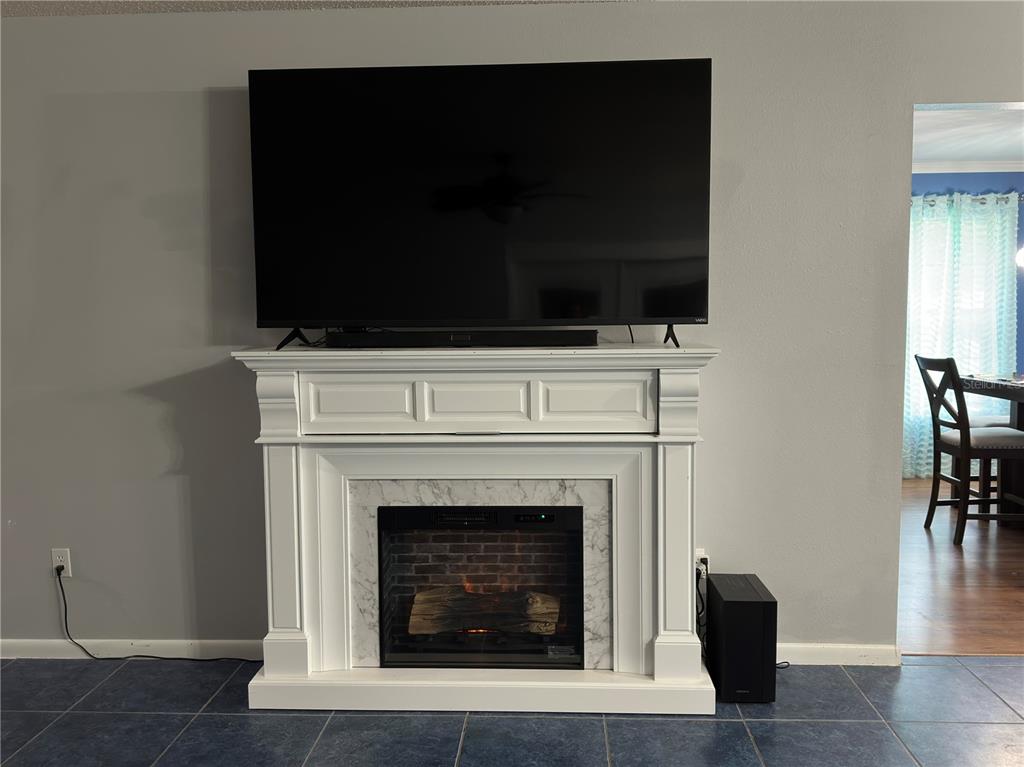 126 Southwest Mockingbird Way Lake City, FL 32024 - Photo 29 of 37 a living room with a fireplace and a flat screen tv