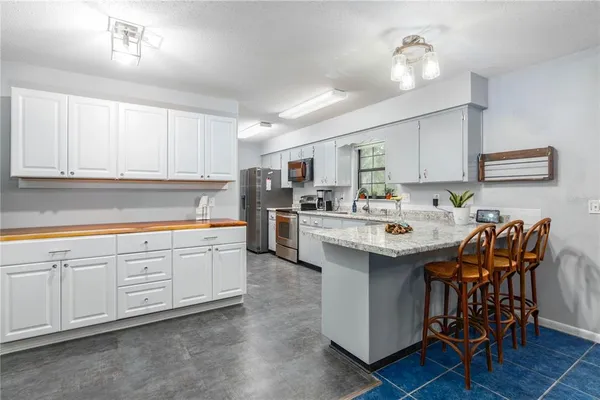 a kitchen with stainless steel appliances kitchen island granite countertop a sink and cabinets