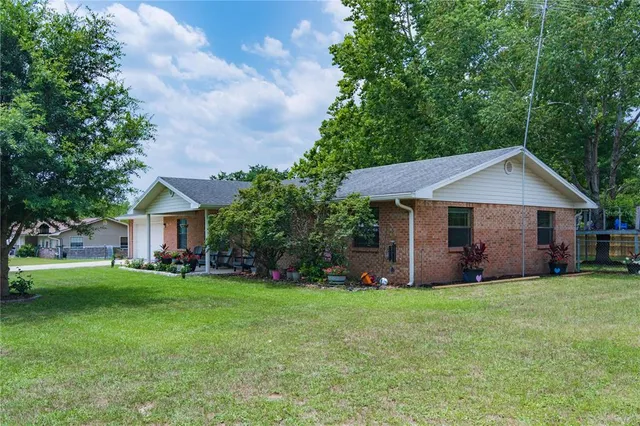 a front view of a house with a yard and trees