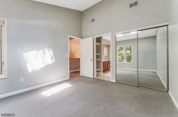 an empty room with a cabinet and mirrors