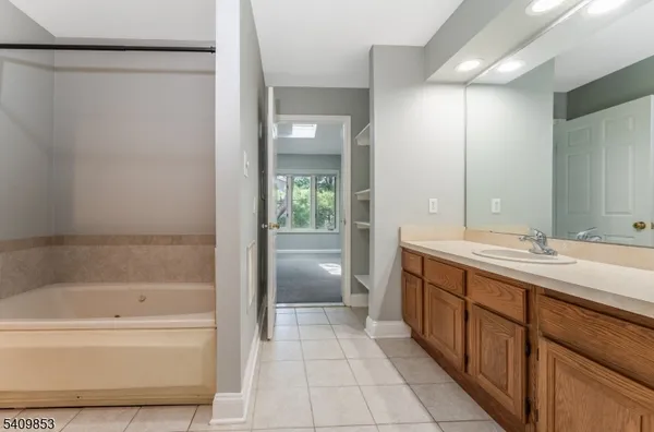 a bathroom with a tub sink and mirror