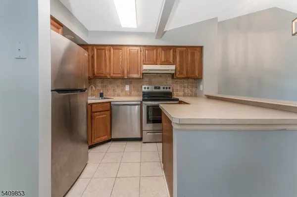 a kitchen with a sink a stove top oven and refrigerator