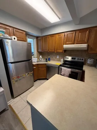 a kitchen with stainless steel appliances a stove a refrigerator and a sink