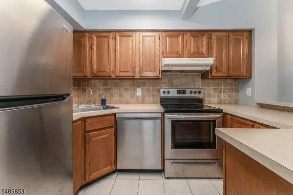 a kitchen with granite countertop a stove sink and cabinets