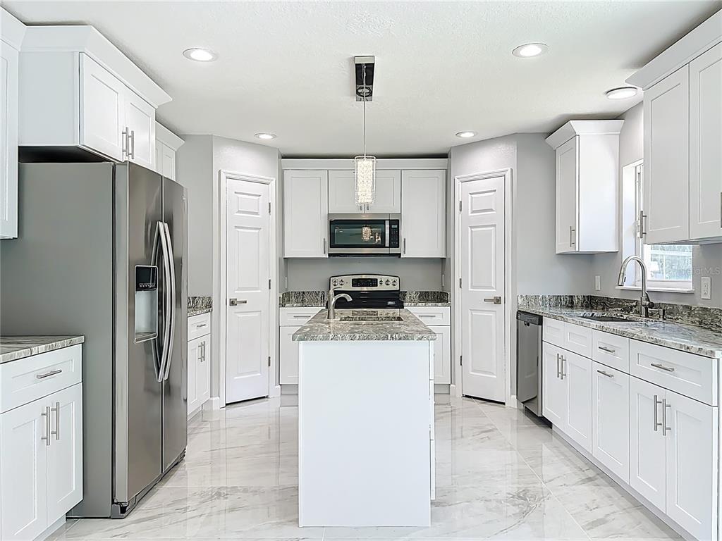 11963 Bentry Street Orlando, FL 32824 - Photo 16 of 80 a kitchen with stainless steel appliances granite countertop a refrigerator stove microwave and sink