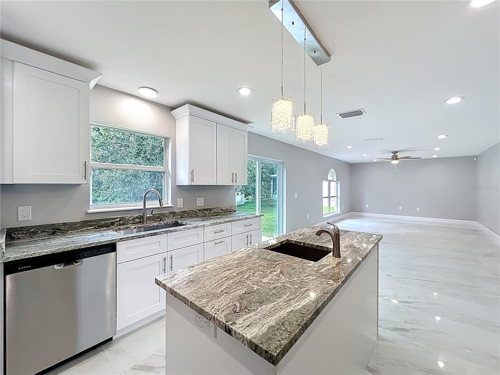 11963 Bentry Street Orlando, FL 32824 - Photo 19 of 80 a kitchen with stainless steel appliances granite countertop a sink a stove and a wooden floors