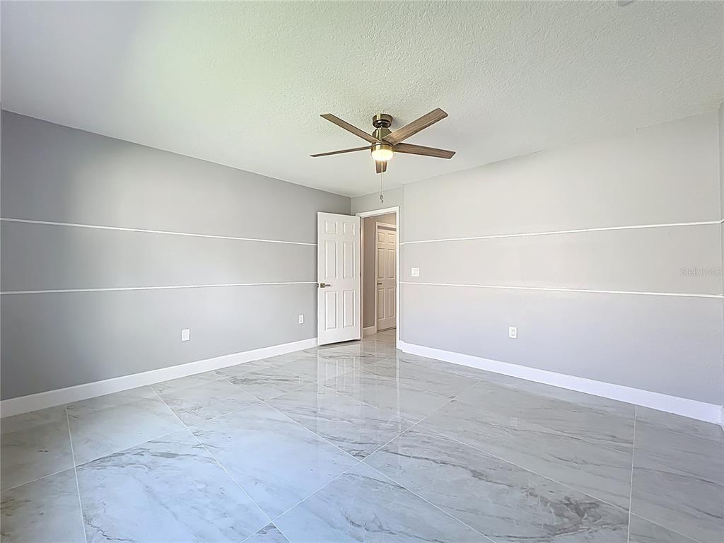 11963 Bentry Street Orlando, FL 32824 - Photo 32 of 80 an empty room with a empty space and a ceiling fan