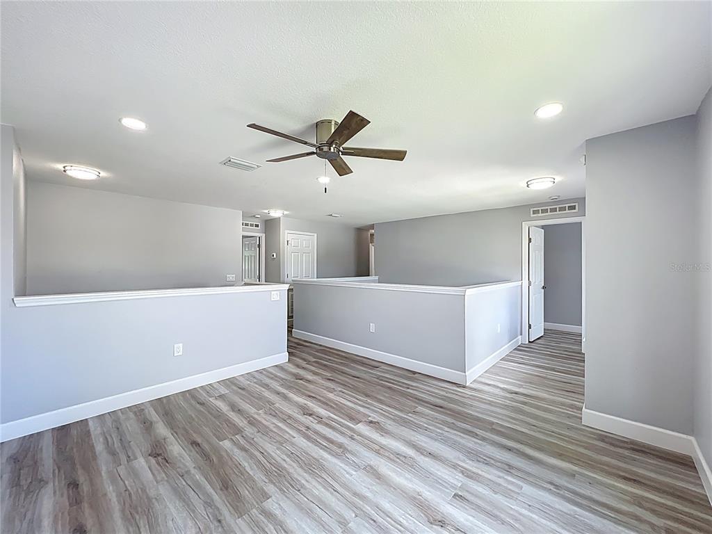 11963 Bentry Street Orlando, FL 32824 - Photo 36 of 80 a view of a big room with wooden floor and a ceiling fan