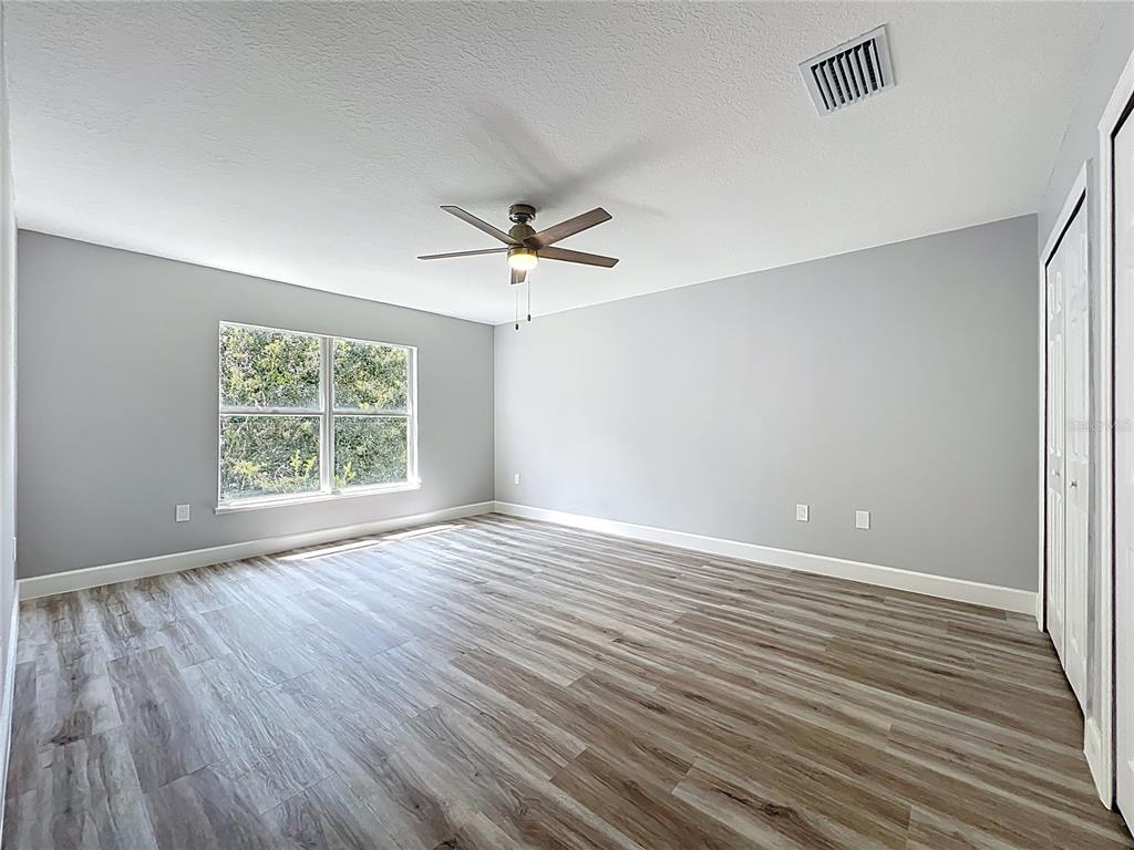 11963 Bentry Street Orlando, FL 32824 - Photo 40 of 80 an empty room with wooden floor and windows