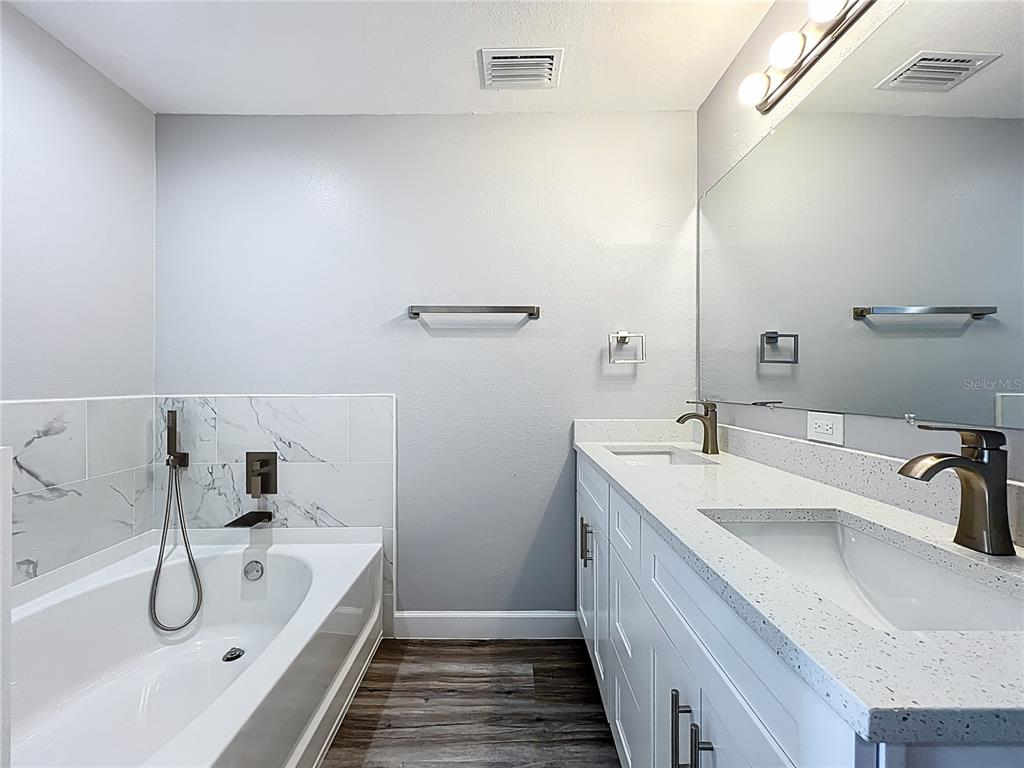 11963 Bentry Street Orlando, FL 32824 - Photo 59 of 80 a bathroom with a double vanity sink and a tub