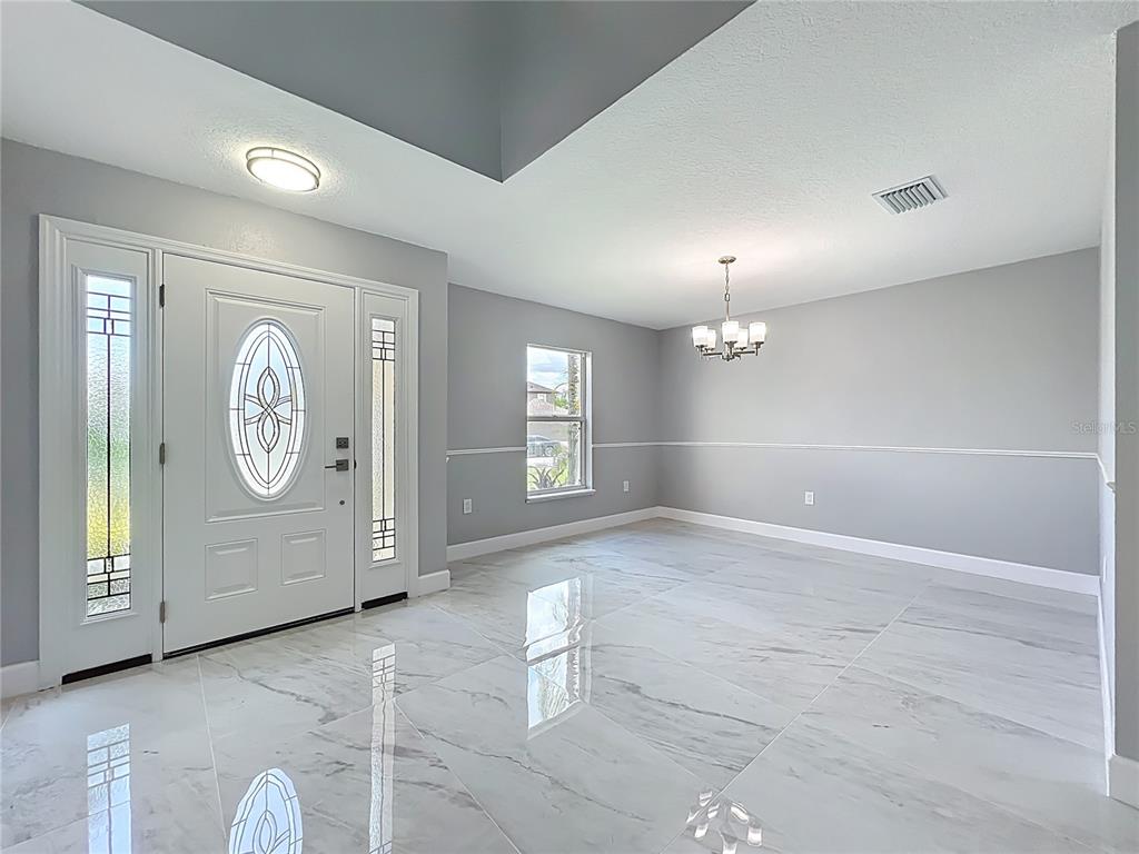 11963 Bentry Street Orlando, FL 32824 - Photo 6 of 80 a view of an empty room with window and hardwood floor