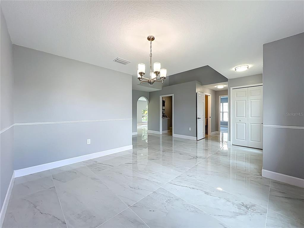 11963 Bentry Street Orlando, FL 32824 - Photo 8 of 80 a view of a hallway with chandelier and refrigerator