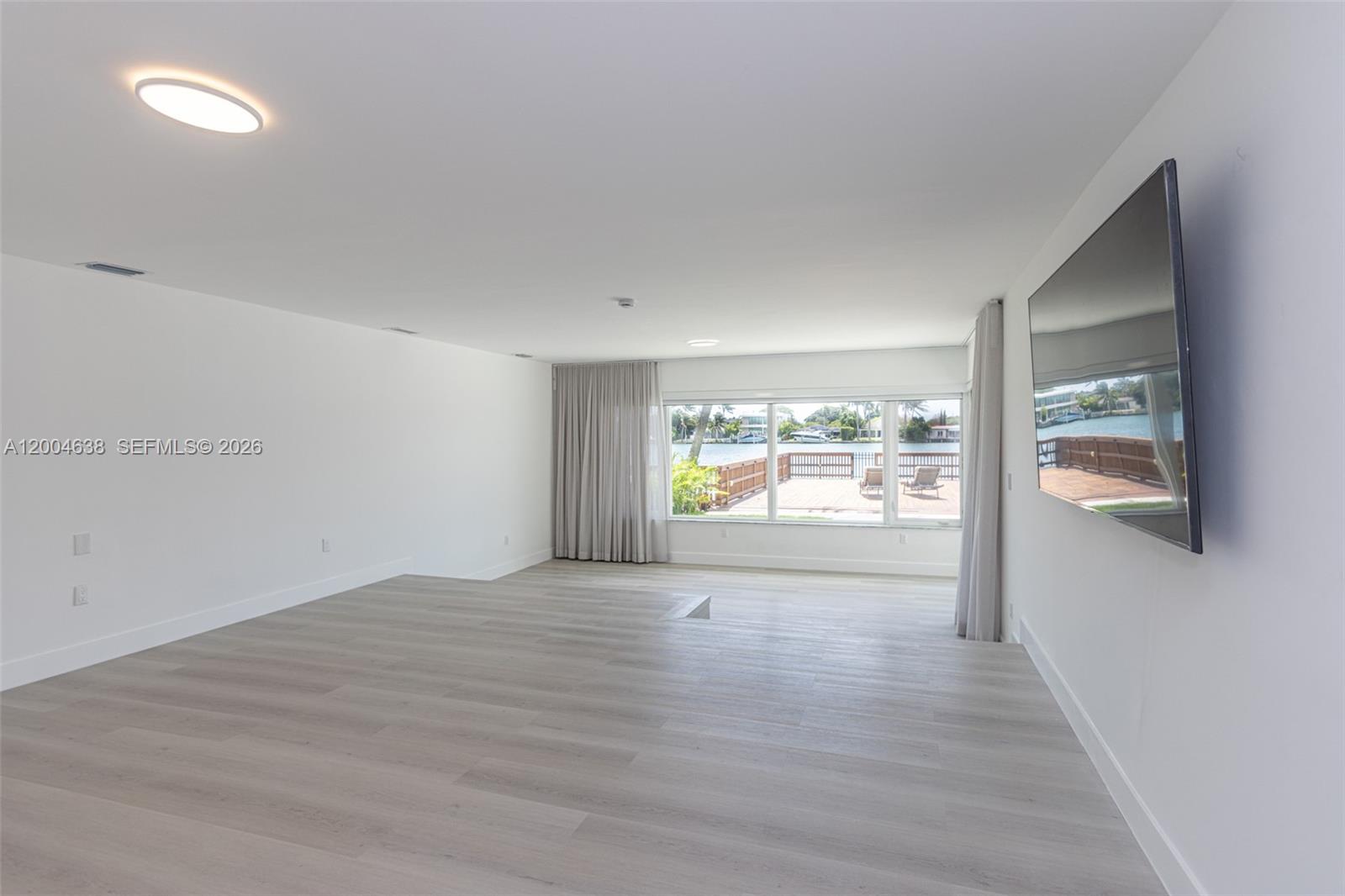 1690 Daytonia Road Miami Beach, FL 33141 - Photo 67 of 88 a view of an empty room with a window and wooden floor